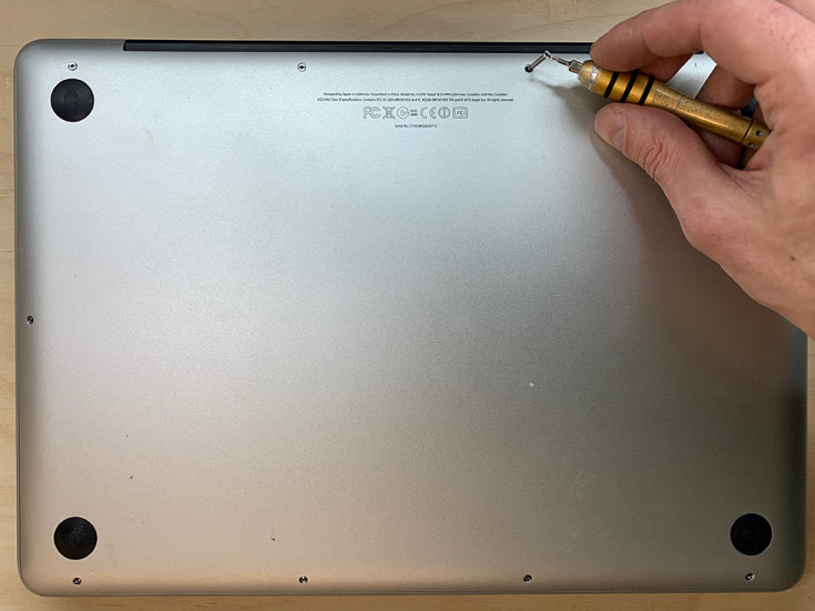 Откручиваем винты на задней крышке MacBook Pro для замены жесткого диска на SSD 