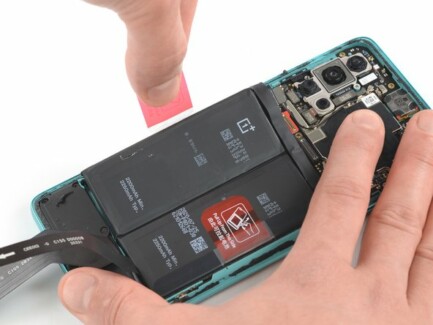 Отогните красный язычок и черную наклейку с левого края батареи смартфона OnePlus 8T